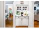Charming butler's pantry with white cabinets and a beverage station featuring marble countertops at 404 Brightling Way, Holly Springs, NC 27540