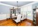 Bright dining room with hardwood floors, a large window, and a decorative chandelier at 404 Brightling Way, Holly Springs, NC 27540