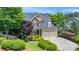 Two-story home with stone accents, two-car garage, and lush landscaping on a sunny day at 404 Brightling Way, Holly Springs, NC 27540