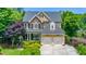 An exterior view of this two-story home featuring a stone facade and a convenient two-car garage at 404 Brightling Way, Holly Springs, NC 27540