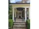 Charming front porch with stone accents, decorative columns, and potted flowers, creating a welcoming entrance to the home at 404 Brightling Way, Holly Springs, NC 27540
