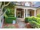 Inviting front porch featuring stone accents, decorative columns, and lush landscaping at 404 Brightling Way, Holly Springs, NC 27540