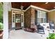 Charming front porch featuring a stone facade, rocking chairs, and a welcoming entrance at 404 Brightling Way, Holly Springs, NC 27540