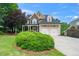 Charming two-story home with a manicured lawn, mature trees, and an attached two-car garage at 404 Brightling Way, Holly Springs, NC 27540