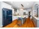 Modern kitchen featuring white cabinetry, an island, stainless steel appliances, and hardwood floors at 404 Brightling Way, Holly Springs, NC 27540