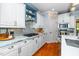 Bright kitchen with white cabinets, hardwood floors, marble countertops, and a stylish backsplash at 404 Brightling Way, Holly Springs, NC 27540