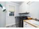 Well-lit laundry room with modern washer and dryer, featuring a white sink and tiled flooring at 404 Brightling Way, Holly Springs, NC 27540
