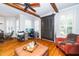 Bright living room with hardwood floors, ceiling fan, built in wardrobe, and a large window at 404 Brightling Way, Holly Springs, NC 27540