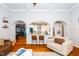 Open-concept living room showcasing hardwood floors, arched openings, and seamless flow into the adjacent kitchen at 404 Brightling Way, Holly Springs, NC 27540