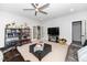 Spacious living room features display shelves, TV, and access to another room through glass doors at 404 Brightling Way, Holly Springs, NC 27540