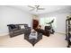 Cozy living room features comfortable seating, ceiling fan, and window views at 404 Brightling Way, Holly Springs, NC 27540