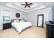 Spacious main bedroom featuring a tray ceiling, ceiling fan, and ample natural light at 404 Brightling Way, Holly Springs, NC 27540