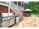 Outdoor kitchen features a grill, mini fridge, and stone countertop at 404 Brightling Way, Holly Springs, NC 27540