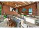 Outdoor dining area with a rustic table, ceiling fan, and wall-mounted TV, perfect for entertaining guests at 404 Brightling Way, Holly Springs, NC 27540