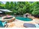 Beautiful backyard pool with a waterfall and lush greenery at 404 Brightling Way, Holly Springs, NC 27540
