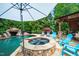 Backyard pool and spa surrounded by a stone patio and lush greenery at 404 Brightling Way, Holly Springs, NC 27540
