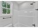 Bathroom featuring a combination shower and tub with white tile surround and matte black fixtures at 405 N Raiford St, Selma, NC 27576