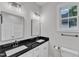 Bathroom featuring double sinks with black countertops and white cabinets and two mirrors at 405 N Raiford St, Selma, NC 27576