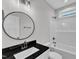 Bathroom featuring modern fixtures, black granite counter, and tub with shower at 405 N Raiford St, Selma, NC 27576