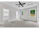 Bright bedroom with ceiling fan, two large windows, a walk in closet, and ensuite bathroom at 405 N Raiford St, Selma, NC 27576