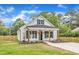 Charming white cottage-style home with black shutters, wood columns, and well-manicured lawn at 405 N Raiford St, Selma, NC 27576