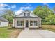 Charming white cottage-style home with black shutters, wood columns, and well-manicured lawn at 405 N Raiford St, Selma, NC 27576