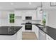 Modern kitchen featuring white cabinets, granite countertops, stainless appliances, and open floor plan at 405 N Raiford St, Selma, NC 27576
