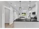 Modern kitchen with white cabinets, black countertops, stainless appliances, and open layout at 405 N Raiford St, Selma, NC 27576
