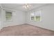 Spacious bedroom with carpeted floors, a ceiling fan, and multiple windows at 407 W Depot St, Angier, NC 27501
