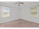 Bright bedroom featuring carpeted floors, a ceiling fan, and two windows at 407 W Depot St, Angier, NC 27501