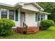 Inviting front porch with brick steps and decorative iron railings at 407 W Depot St, Angier, NC 27501