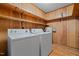 Inside laundry room with wood paneled walls and shelves above the washer and dryer at 407 W Depot St, Angier, NC 27501