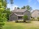 A full backyard view with mature trees, and a screened porch at 420 Creekhurst Pl, Cary, NC 27519