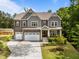 Inviting two-story home with a three-car garage, manicured lawn, and beautiful landscaping at 420 Creekhurst Pl, Cary, NC 27519