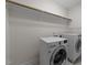 Functional laundry room equipped with modern washer and dryer units, complemented by overhead shelving for storage at 420 Creekhurst Pl, Cary, NC 27519