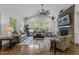 Spacious living room with hardwood floors, stone fireplace, ceiling fan, and plenty of natural light at 420 Creekhurst Pl, Cary, NC 27519