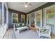 Relaxing screened porch with neutral furniture and ceiling fan at 420 Creekhurst Pl, Cary, NC 27519