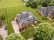 An aerial view of a beautiful brick home showcasing a well-maintained lawn, patio, landscaping, and a private driveway at 4266 Aviemore Run, Burlington, NC 27215