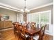 Elegant dining room featuring a large wooden table, chandelier, and ample natural light at 4266 Aviemore Run, Burlington, NC 27215