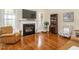 Cozy living room featuring a fireplace, hardwood floors, and comfortable seating arrangements at 4266 Aviemore Run, Burlington, NC 27215