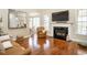 Bright living room with a fireplace, hardwood floors, and open layout flowing to the dining area at 4266 Aviemore Run, Burlington, NC 27215
