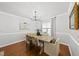 Bright dining room with hardwood floors, modern chandelier, and seating for six at 4621 Youngsbury Ct, Raleigh, NC 27604