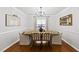 Bright dining room with hardwood floors, modern chandelier, and seating for six at 4621 Youngsbury Ct, Raleigh, NC 27604
