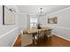Bright dining room with hardwood floors, modern chandelier, and seating for six at 4621 Youngsbury Ct, Raleigh, NC 27604