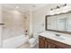 Traditional bathroom featuring a shower-tub combo, neutral tile, and a dark wood vanity with natural light at 528 Bankhead Dr, Cary, NC 27519