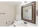 Bathroom with decorative mirror, a white sink, and view of the tiled shower in the background at 528 Bankhead Dr, Cary, NC 27519