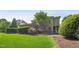Rear home exterior view showing lush green lawn, privacy hedges and beds of roses for a welcoming and serene outdoor space at 528 Bankhead Dr, Cary, NC 27519