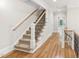 Staircase with hardwood floors, white trim, and iron railings at 528 Bankhead Dr, Cary, NC 27519