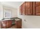 Laundry room featuring ample counter space, wood cabinets, sink, and natural light from the window at 528 Bankhead Dr, Cary, NC 27519