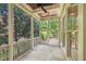 Screened porch featuring a stone tile floor, wood ceiling, ceiling fan, and screens with green scenery at 528 Bankhead Dr, Cary, NC 27519